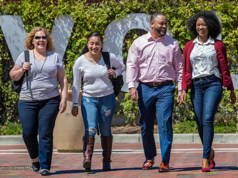 Four people walk together.