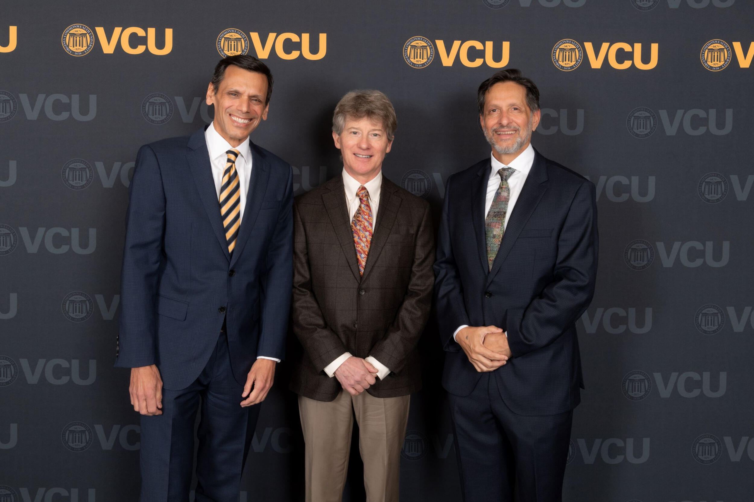 Michael Rao, R. Todd Stravitz and Arun Sanyal lined up in front of VCU logo.