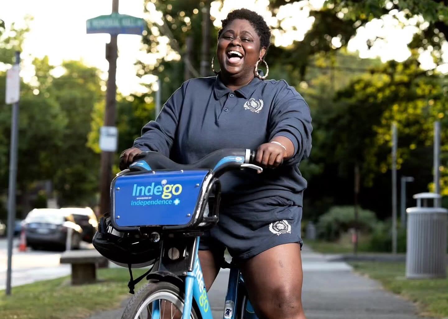 A photo of a woman standing over a blue bike. 