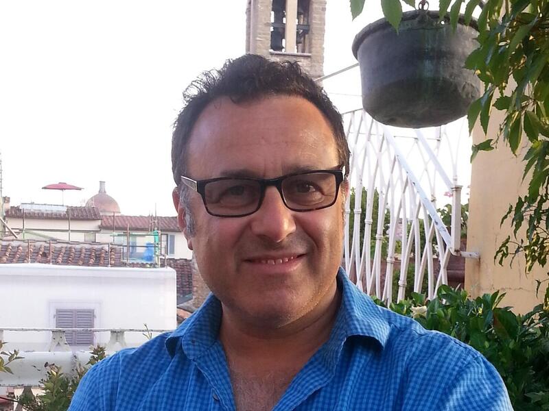 A photo of a man wearing a button up shirt and sunglasses 