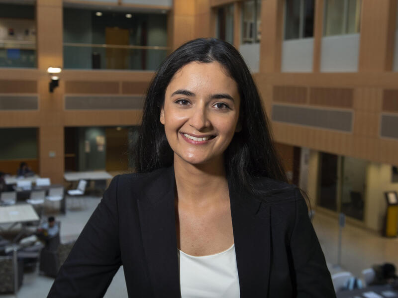 A woman wearing a blazer and dress shirt smiling 