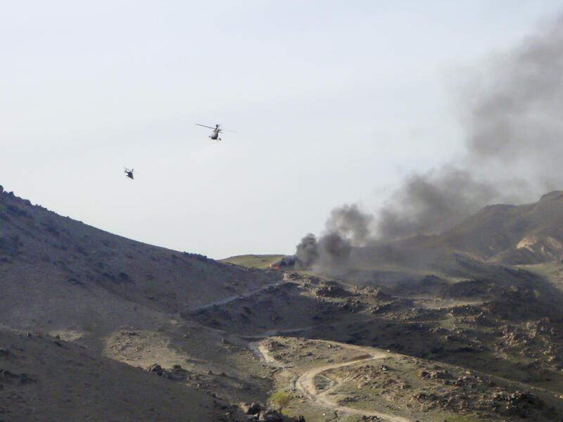 Helicopters flying over a bombing in Afghanistan.