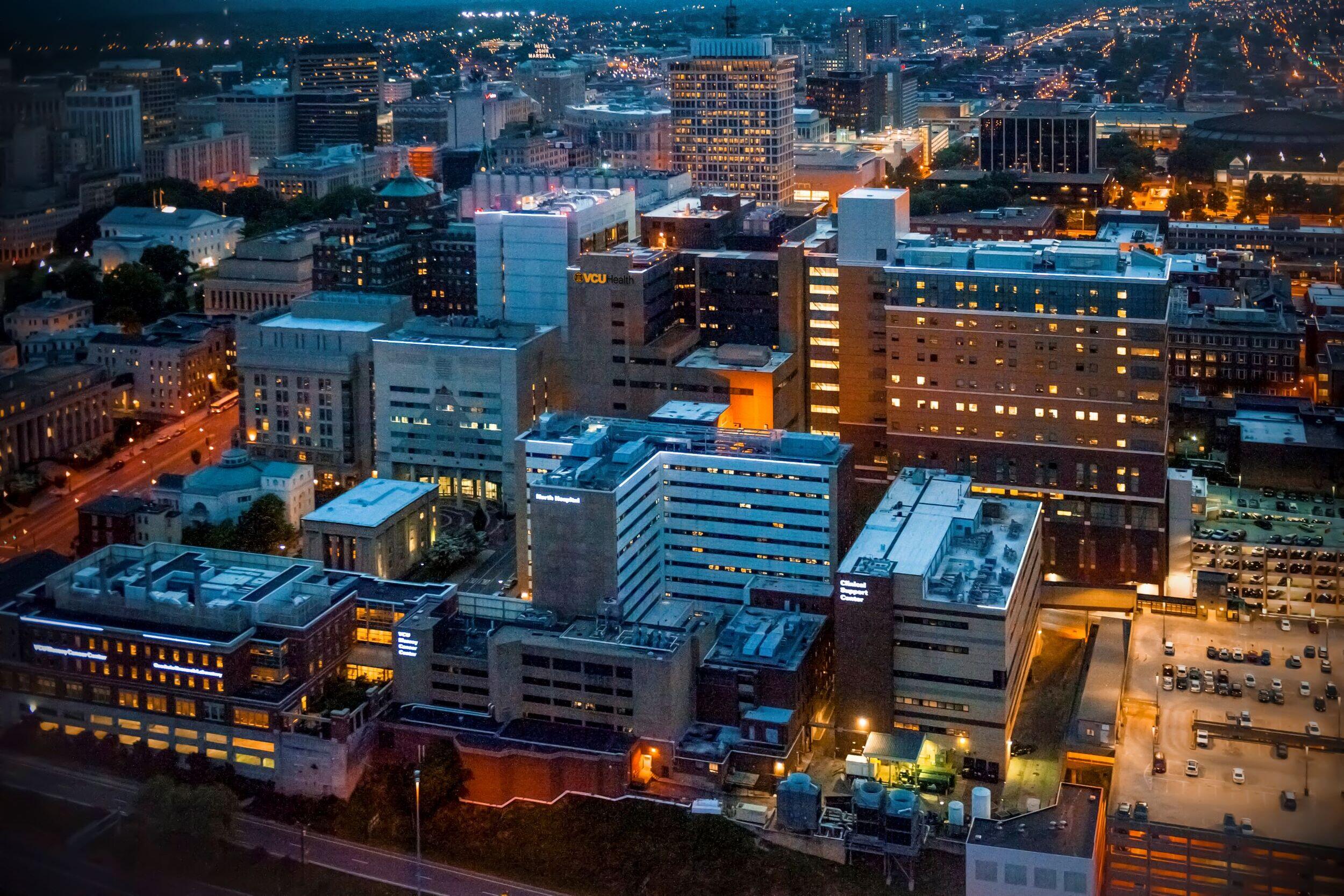 A photo of the MCV campus at night with building lights 