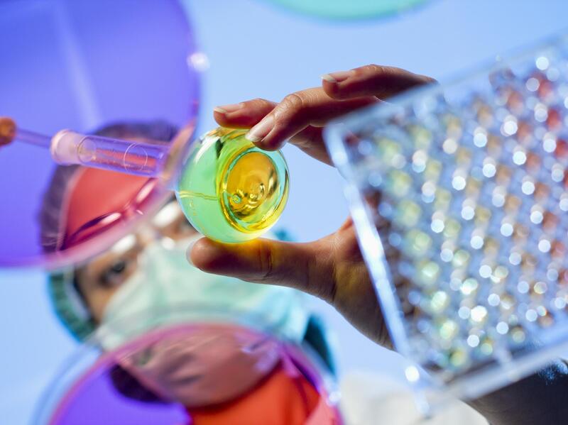 A woman putting liquid into a test tube