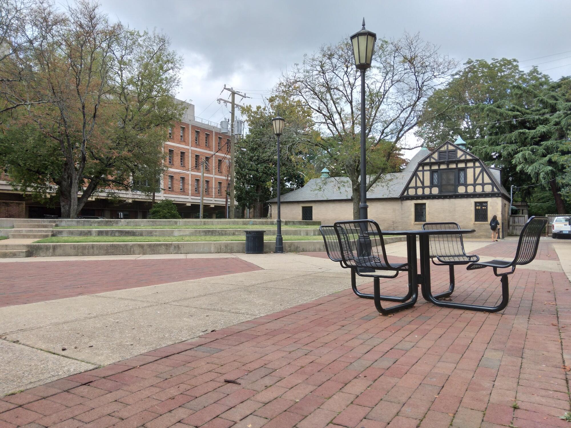 an empty park bench in a brick plaza