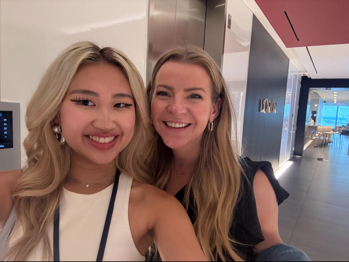 A selfie of two women standing in an hallway. 