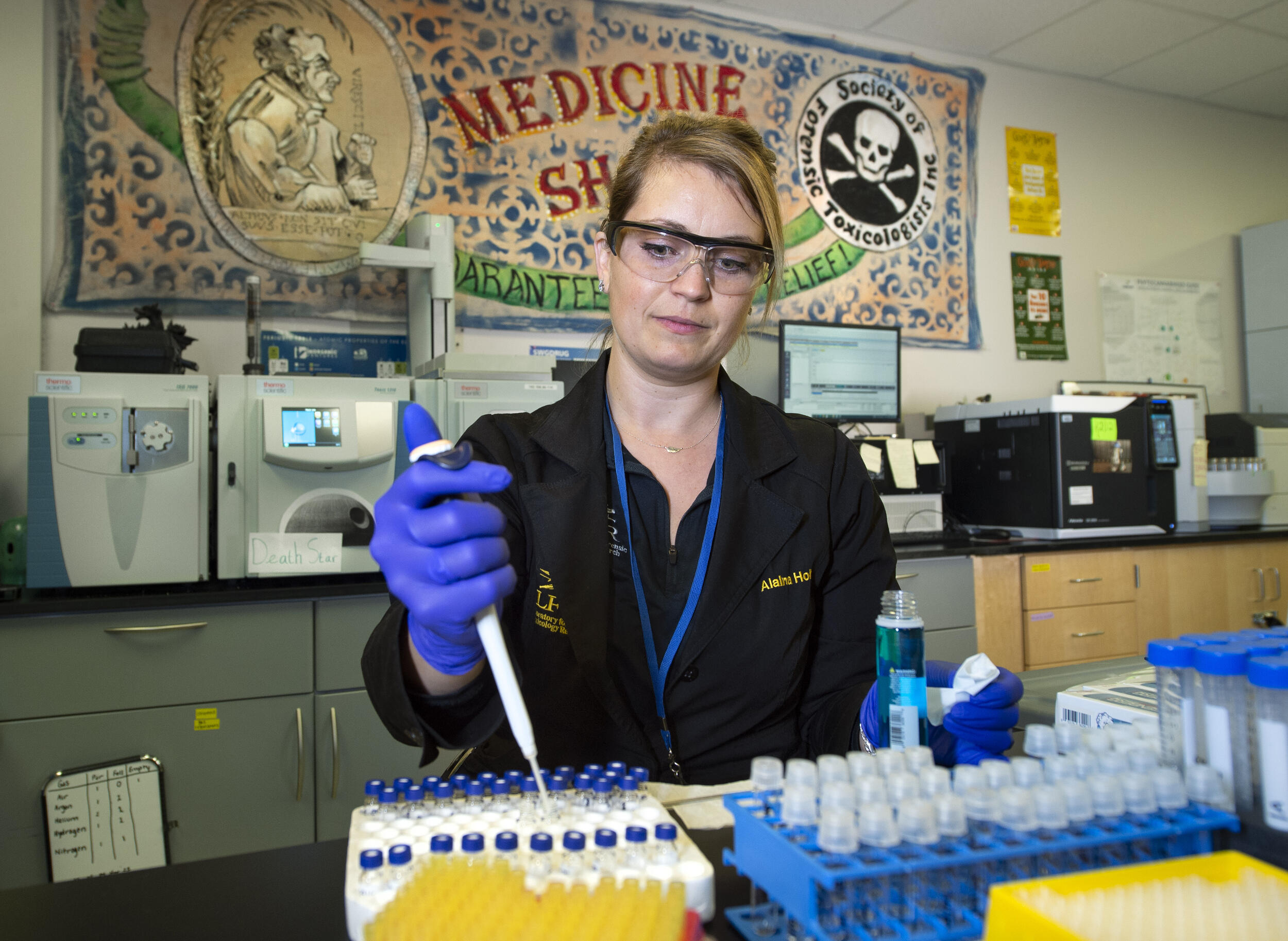 A photo of a woman filling small vials 