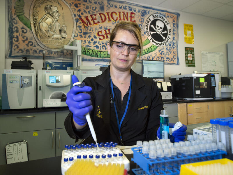 A photo of a woman filling small vials 
