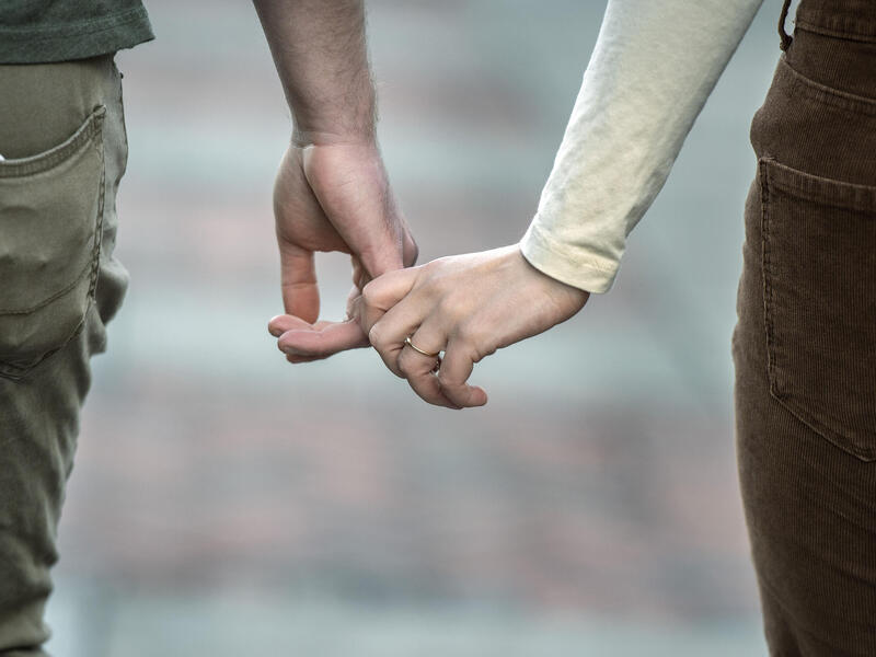 A photot of two people holding hands 