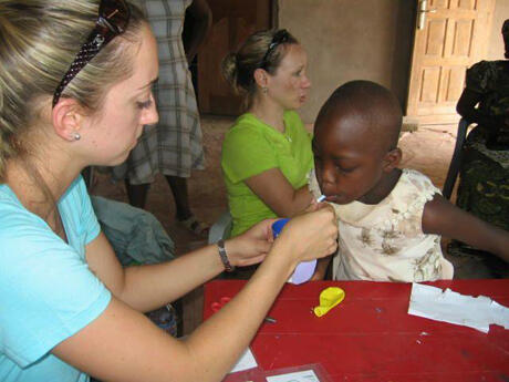 Meredith Cofield, an OT student, works with young Elizabeth who has Down's Syndrome. Pictured in the background is Stacey Reynolds, who is explaining to the parents how working on good lip closure will strengthen Elizabeth’s mouth muscles and help improve her speech and self-feeding abilities.

Photo by Susan Phipps