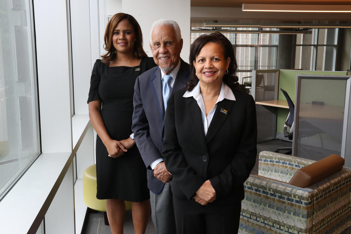 Two women standing next to a man