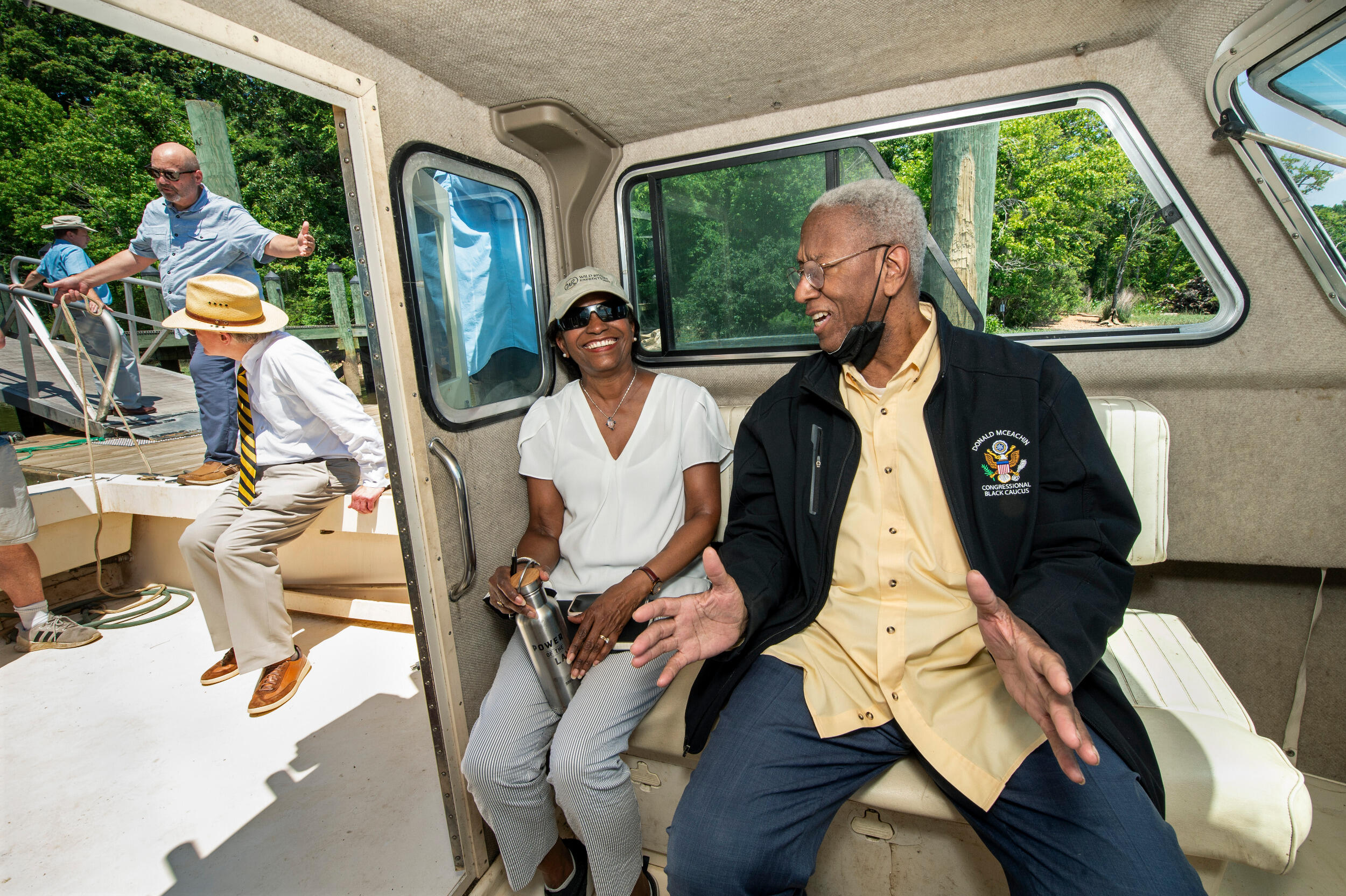 White House Council on Environmental Quality Chair Brenda Mallory and U.S. Rep. A. Donald McEachin sitting on a boat and laughing.
