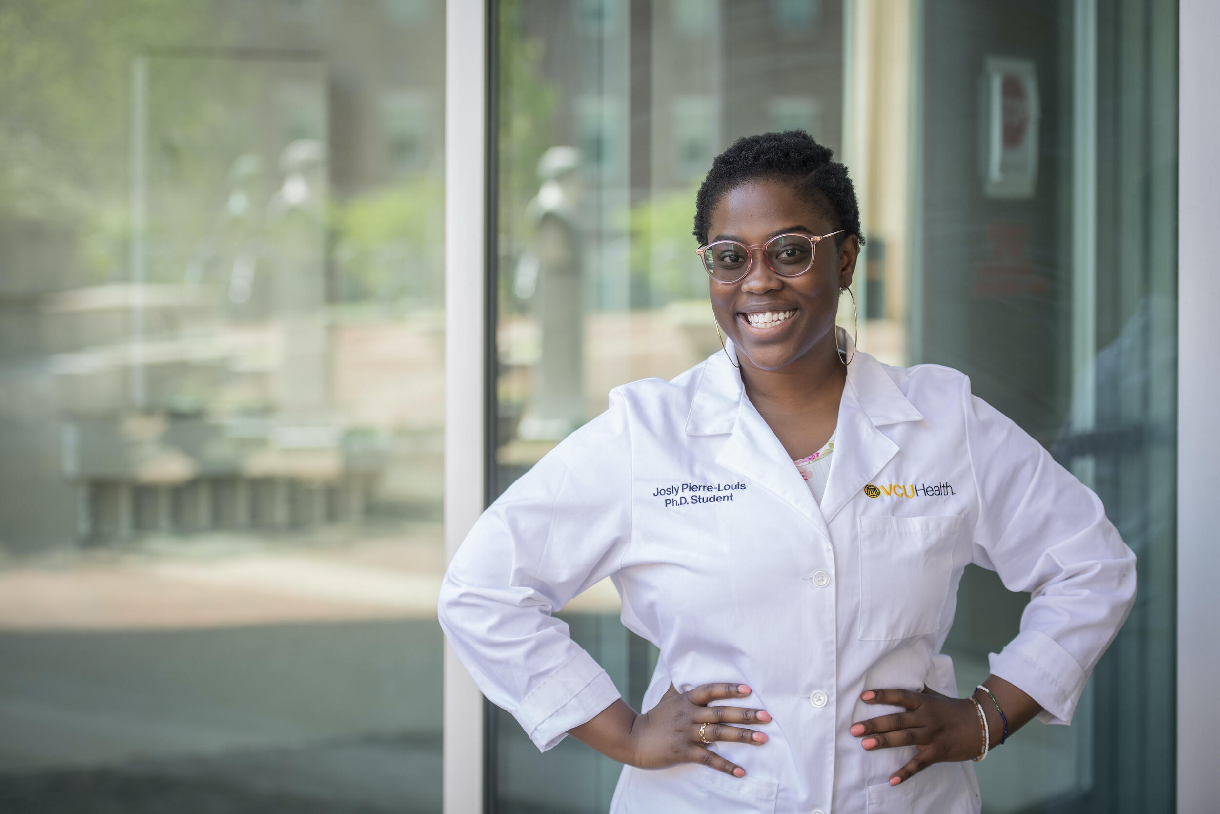 Josly Pierre-Louis wearing a white doctor's coat.