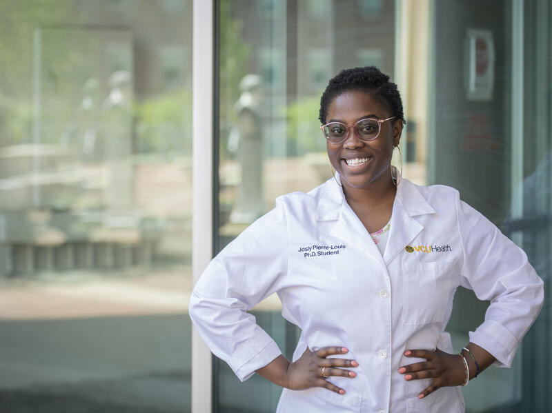 Josly Pierre-Louis wearing a white doctor's coat.