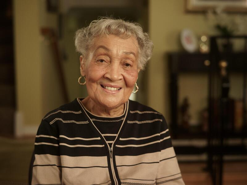 Florence Smith smiling wearing a brown and beige striped cardigan