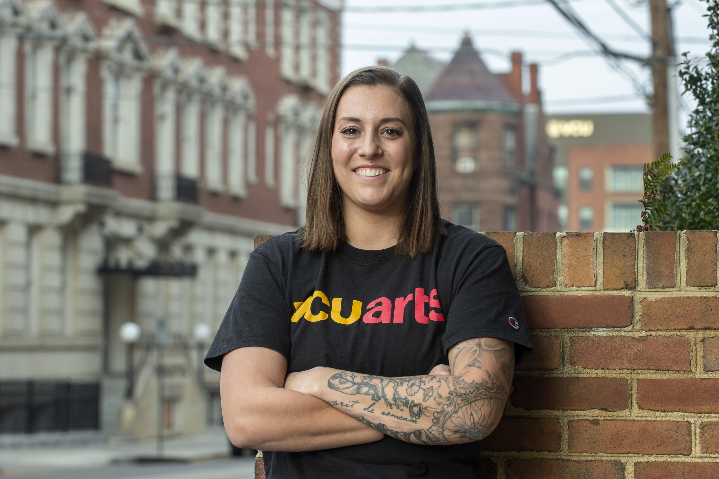 Leah Agler standing in front of a brick wall.