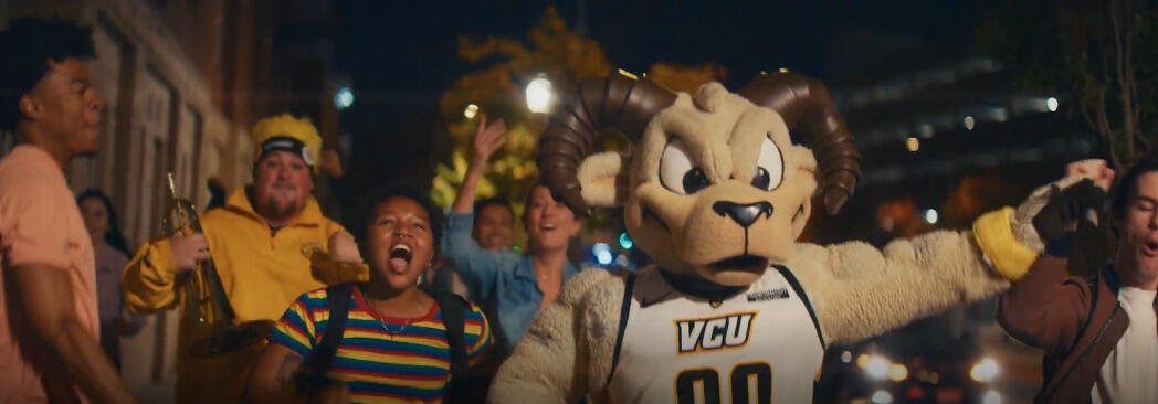 A photo of people cheering around a Rodney the Ram mascot. 