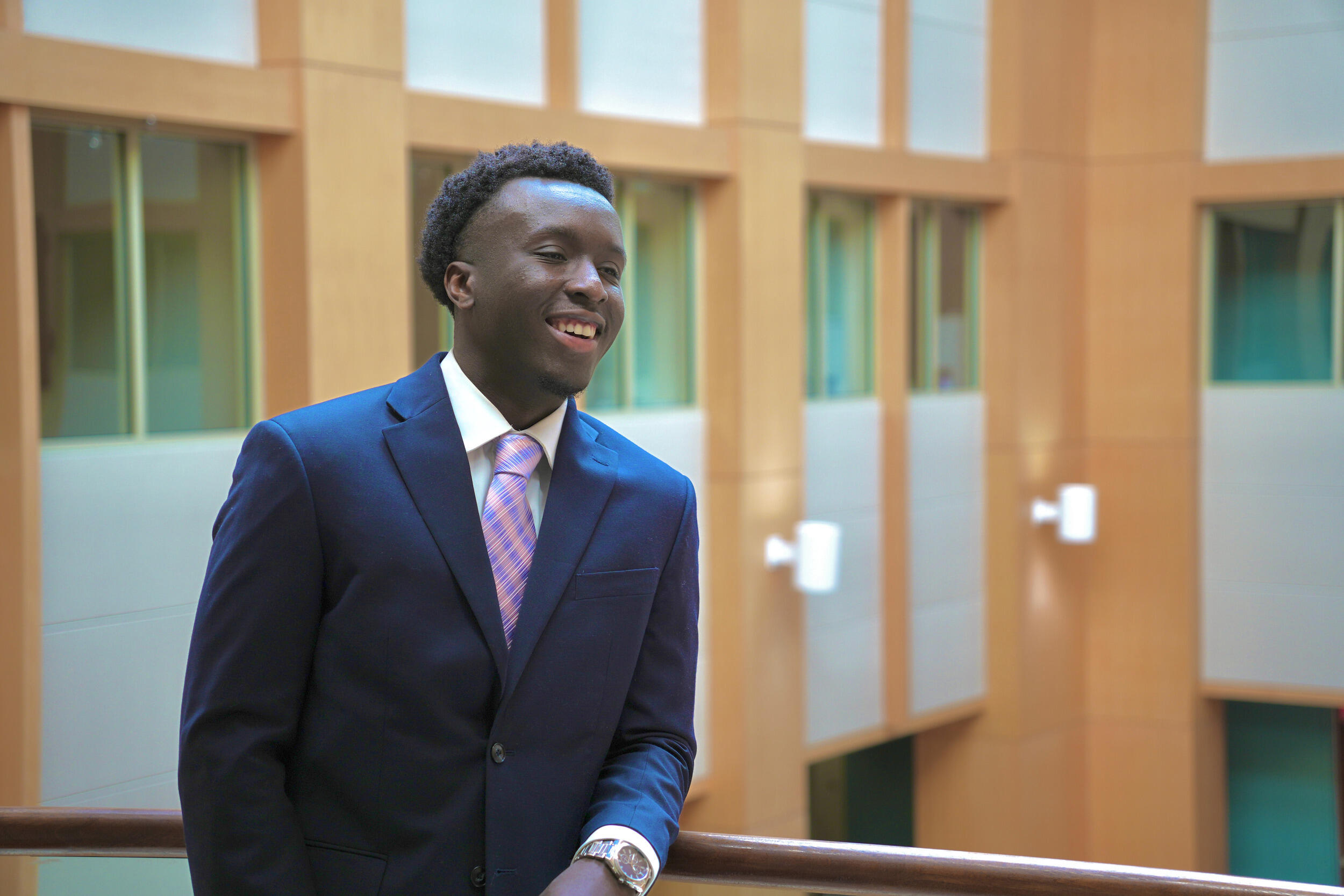 A photo of a man from the waist up. He is wearing a suit and tie. 
