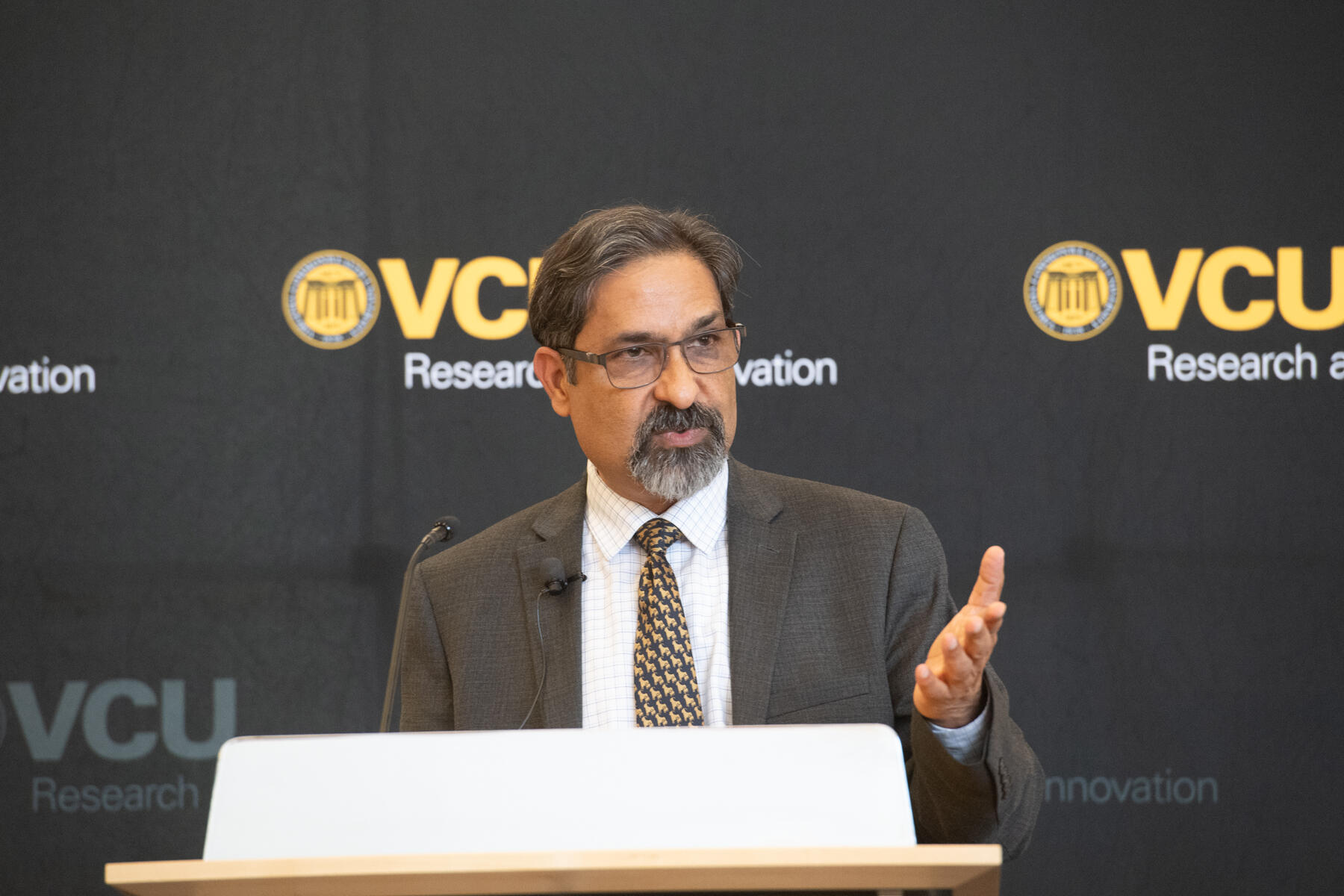 A photo of a man standing behind a podium. 
