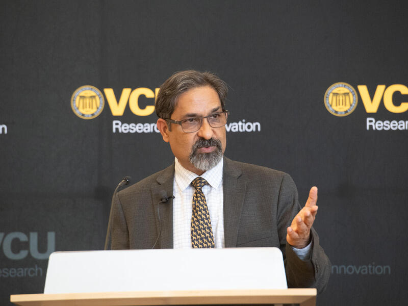 A photo of a man standing behind a podium. 