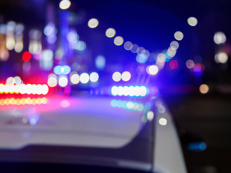 A blurry photo of police lights and street lights 