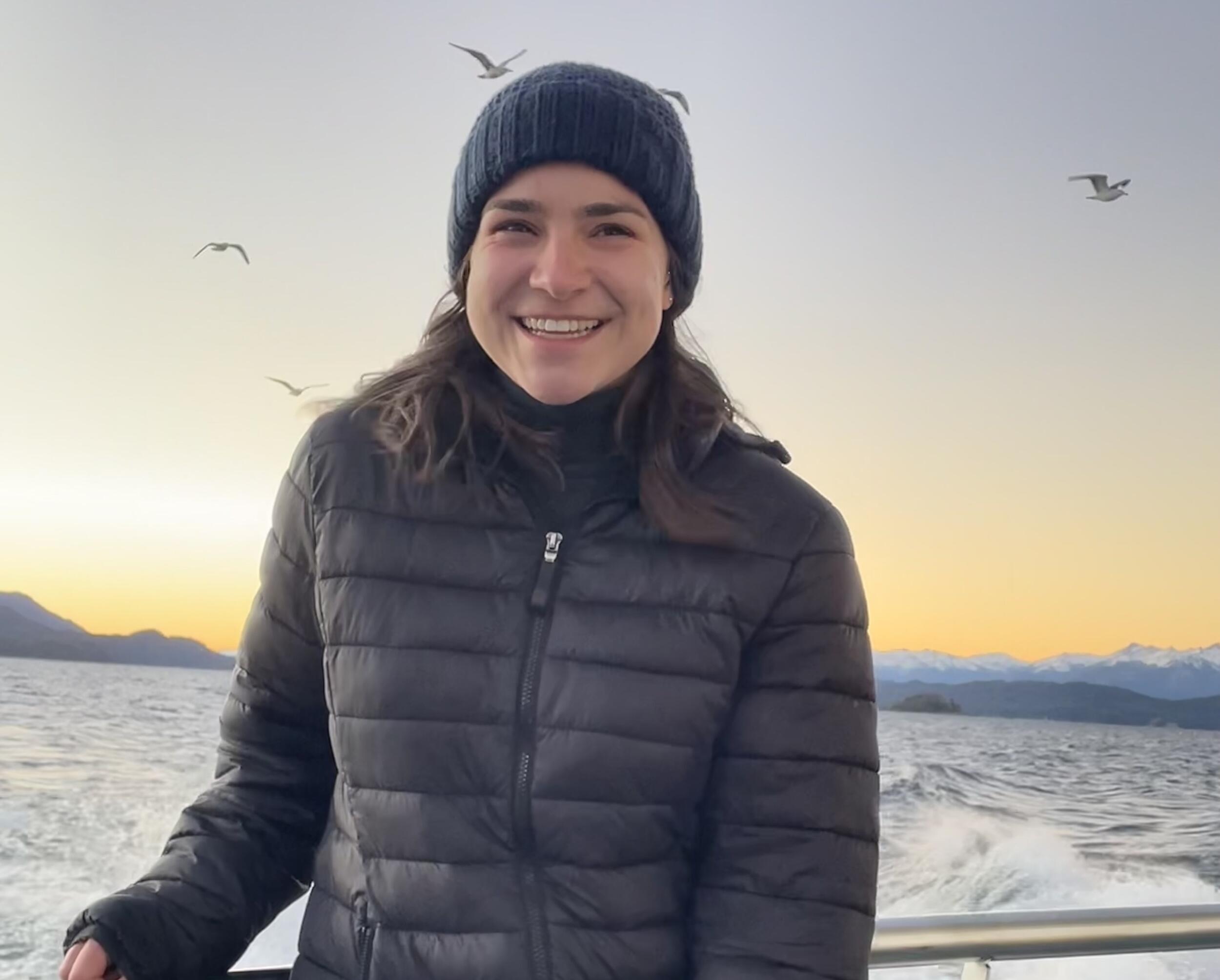 A portrait of Leslie Bolda standing on a boat with water behind her. 
