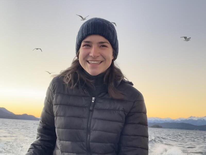 A portrait of Leslie Bolda standing on a boat with water behind her. 