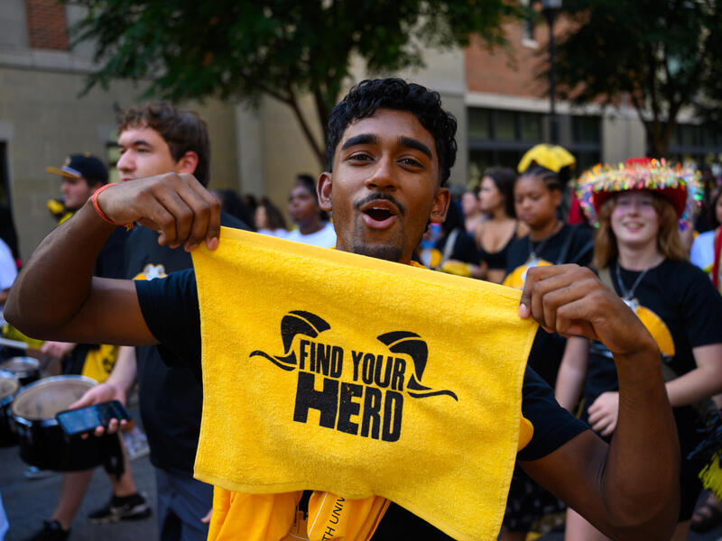 A man holds up a gold towel.