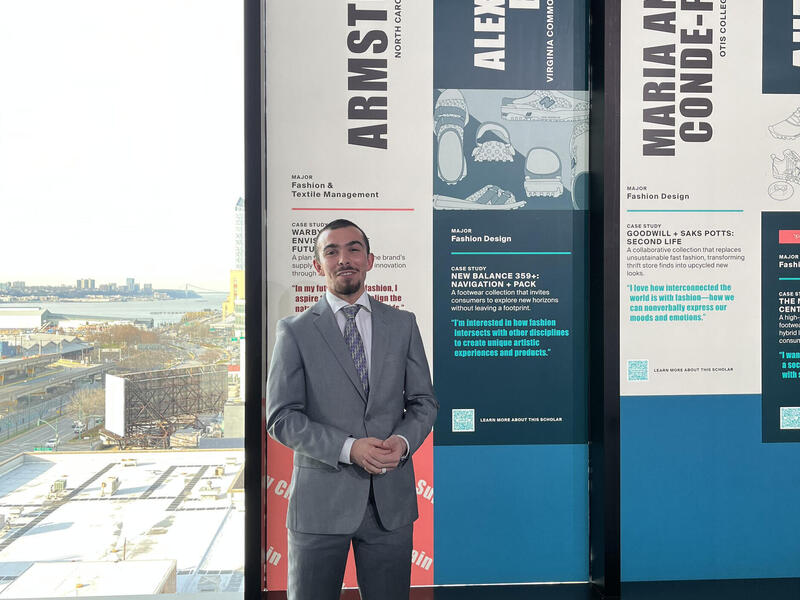 Alexander Britto standing in front of floor to ceiling windows, some of which are covered in graphics 