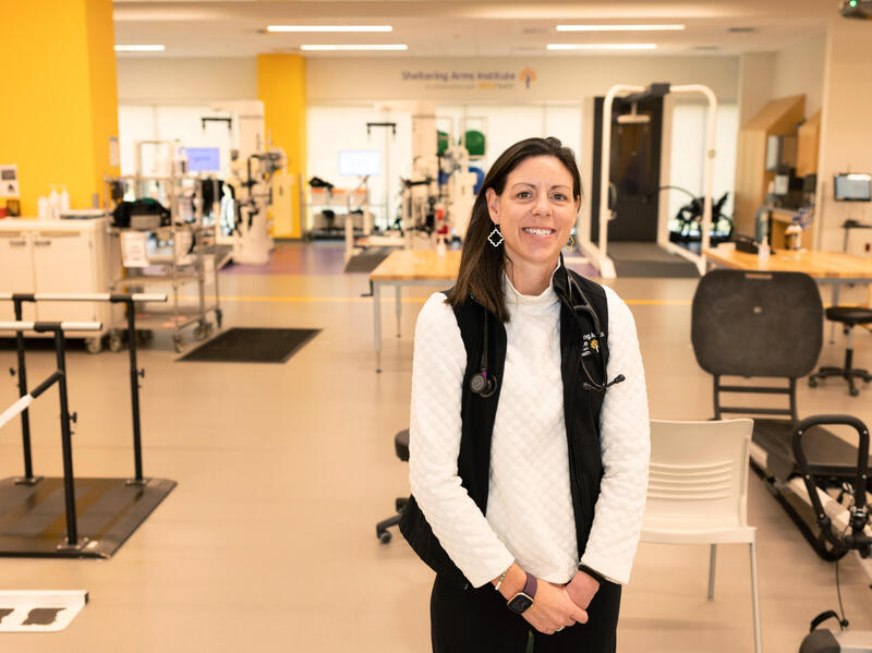 A photo of a woman standing ina physical therapy office. 