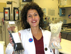 Dr. Therese Duane shows PolyHeme and saline solution, the two blood expanders that will be used by first responders in the proposed study.

Photo Credit: Michael Ford, University News Services