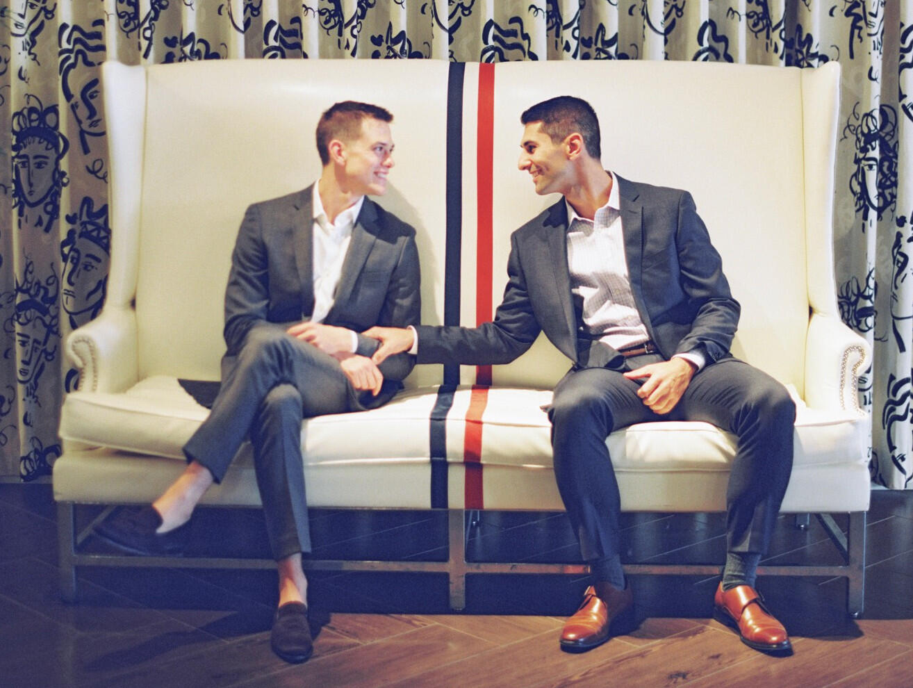 Two people seated in large, white chairs.