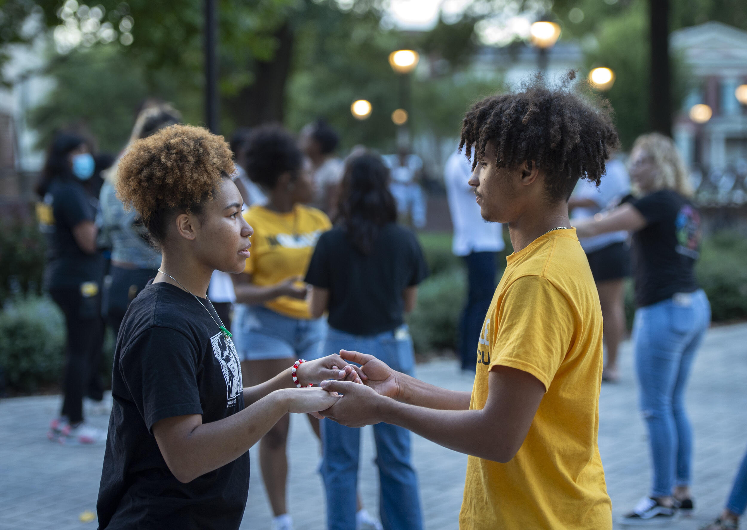 A man and woman holding hands facing each other 