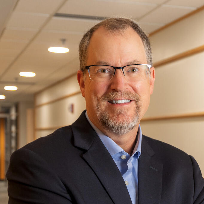 A smiling man in glasses.