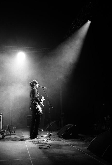 Rebecca Gates performing onstage, playing the guitar.