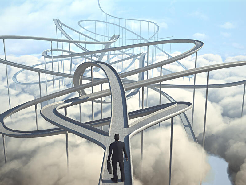 Artwork of a person in a business suit standing before multiple walkways.