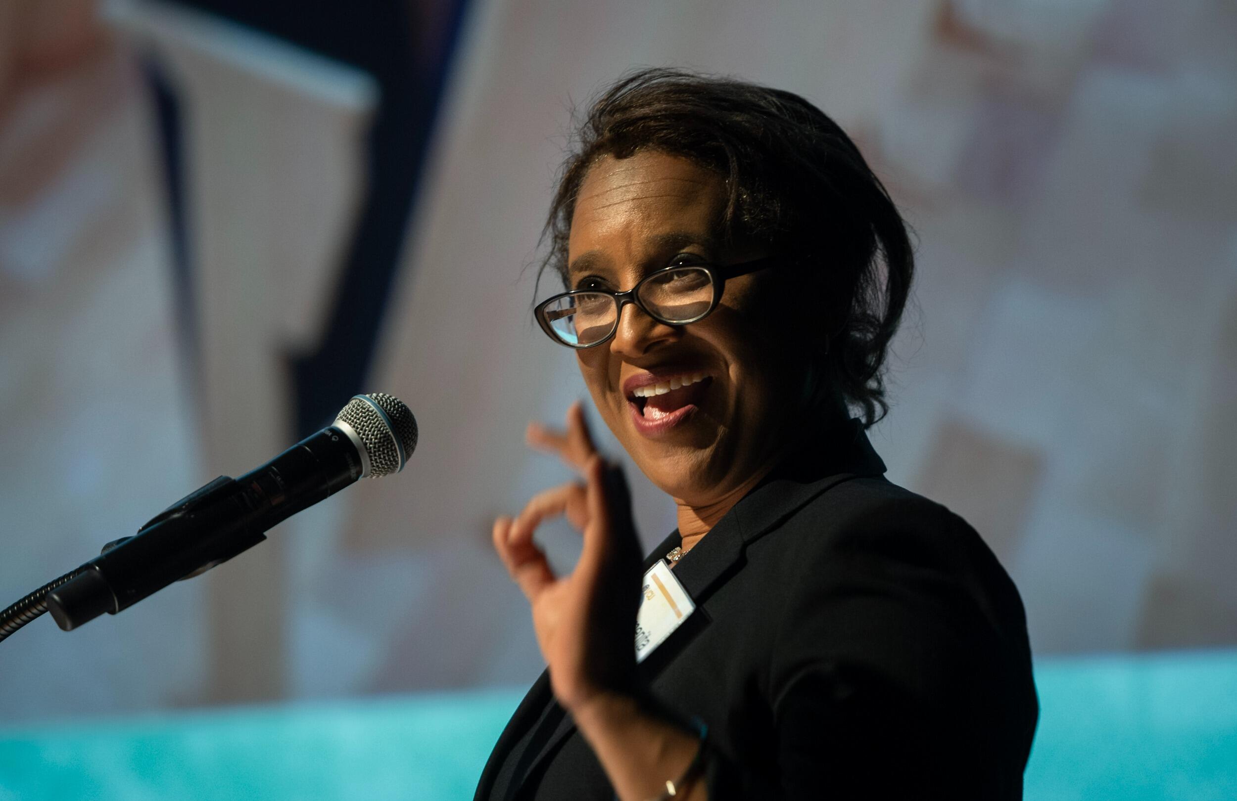 A photo of a woman speaking into a microphone 