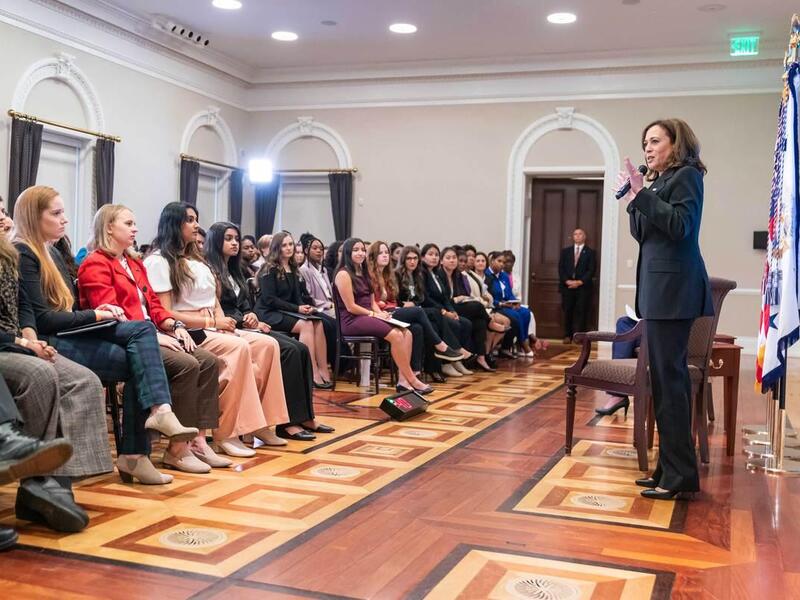 Vice President Kamala Harris speaks with a microphone to a crowd of seated college students.