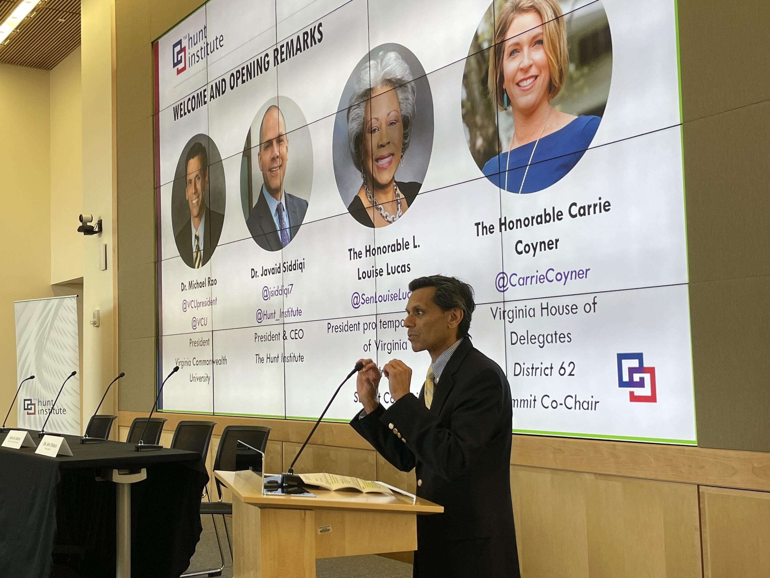 A photo of a man speaking at a podium