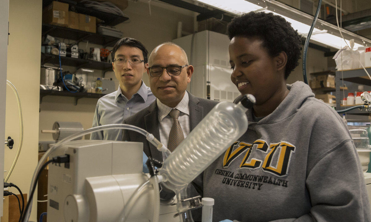 Mo Jiang, Ram B. Gupta, and Jethrine Mugumya inside of a laboratory.