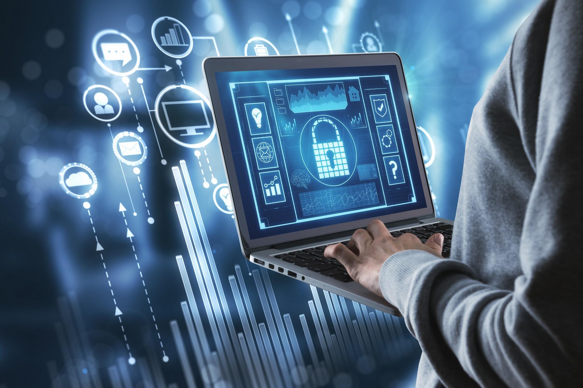 A stock image showing a person typing on a laptop computer displaying a mock security suite. Icons from the suite are displayed in the background the computer.