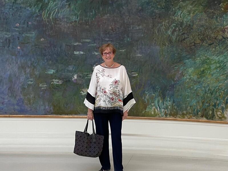 A woman standing in front ofa blue and green painting 