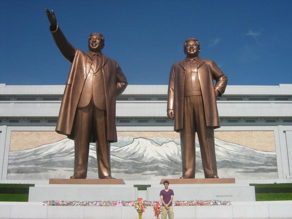 Benjamin Young stands in front of the two giant statues at the Mansu Hill Grand Monument in North Korea.