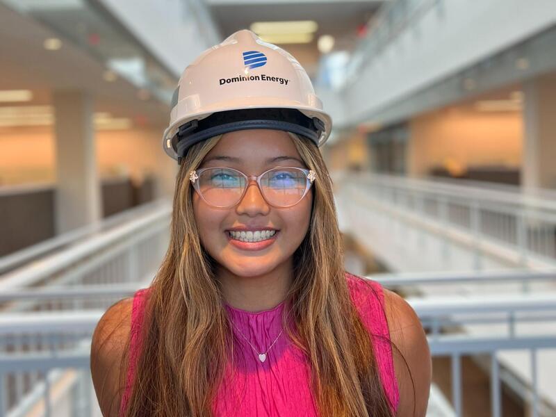 A photo of a woman wearing a hard hat and safety glasses. 