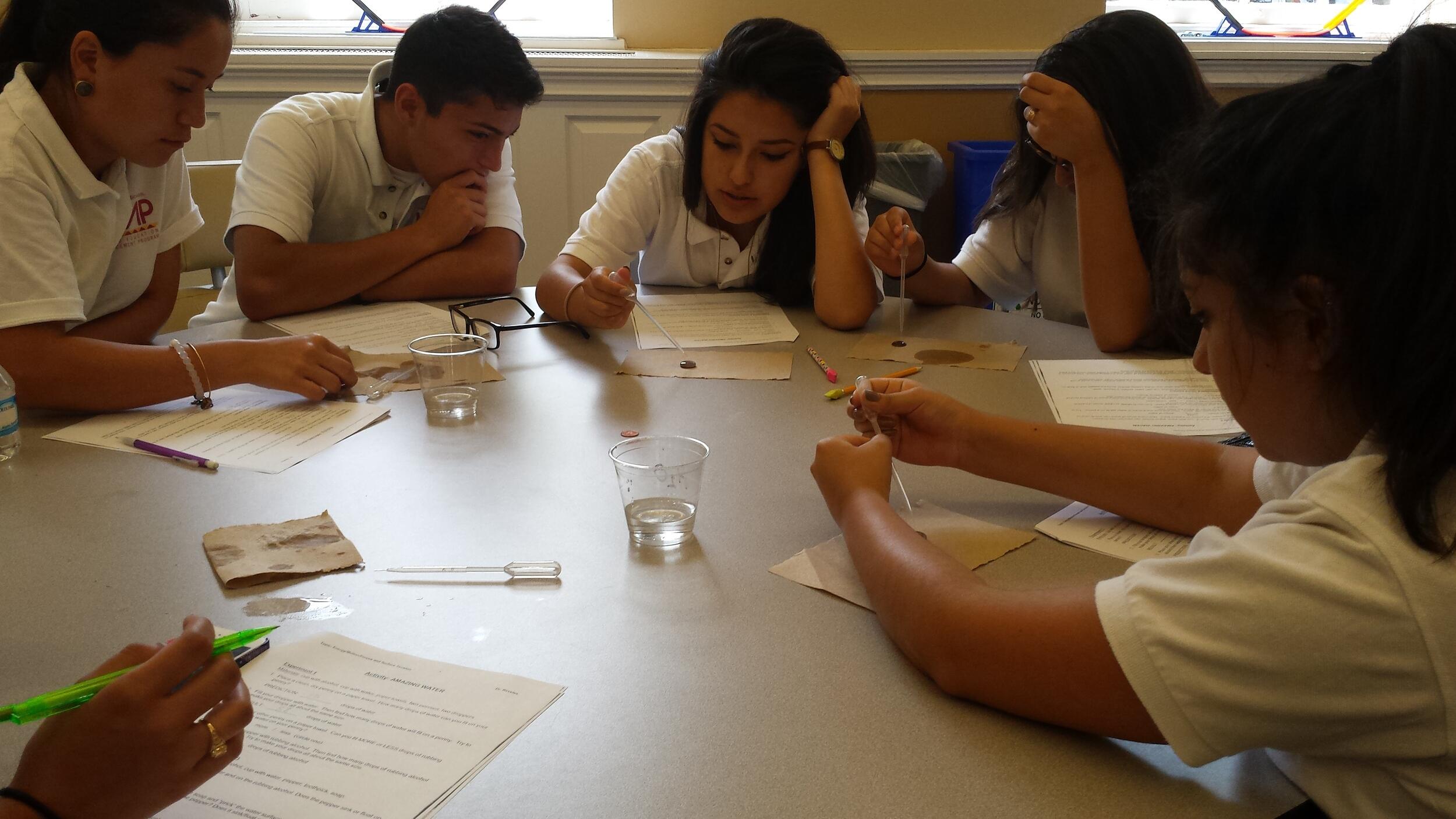 LEAP students testing the maximum number of drops that a penny can hold.