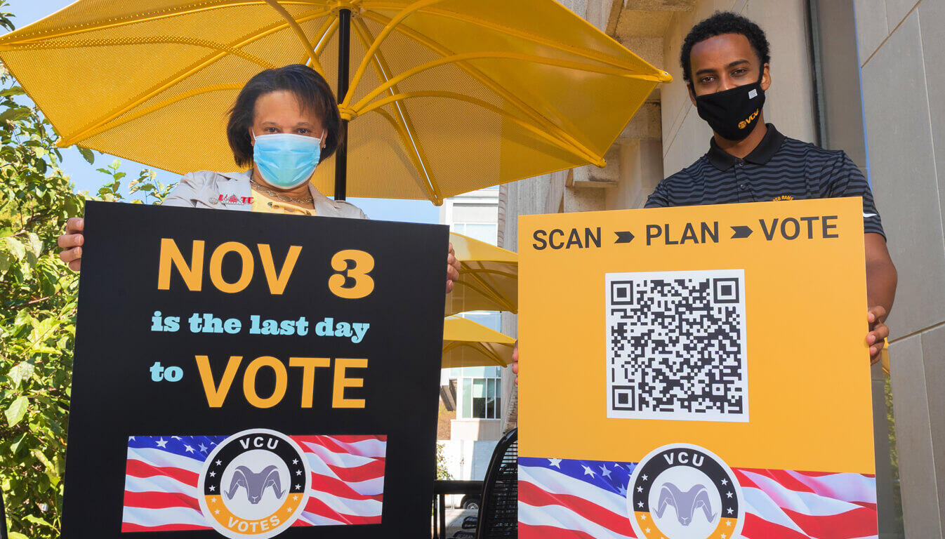 Jacqueline Smith-Mason, Ph.D. and Matt Tessema each holding V C U Votes signs encouraging people to vote.