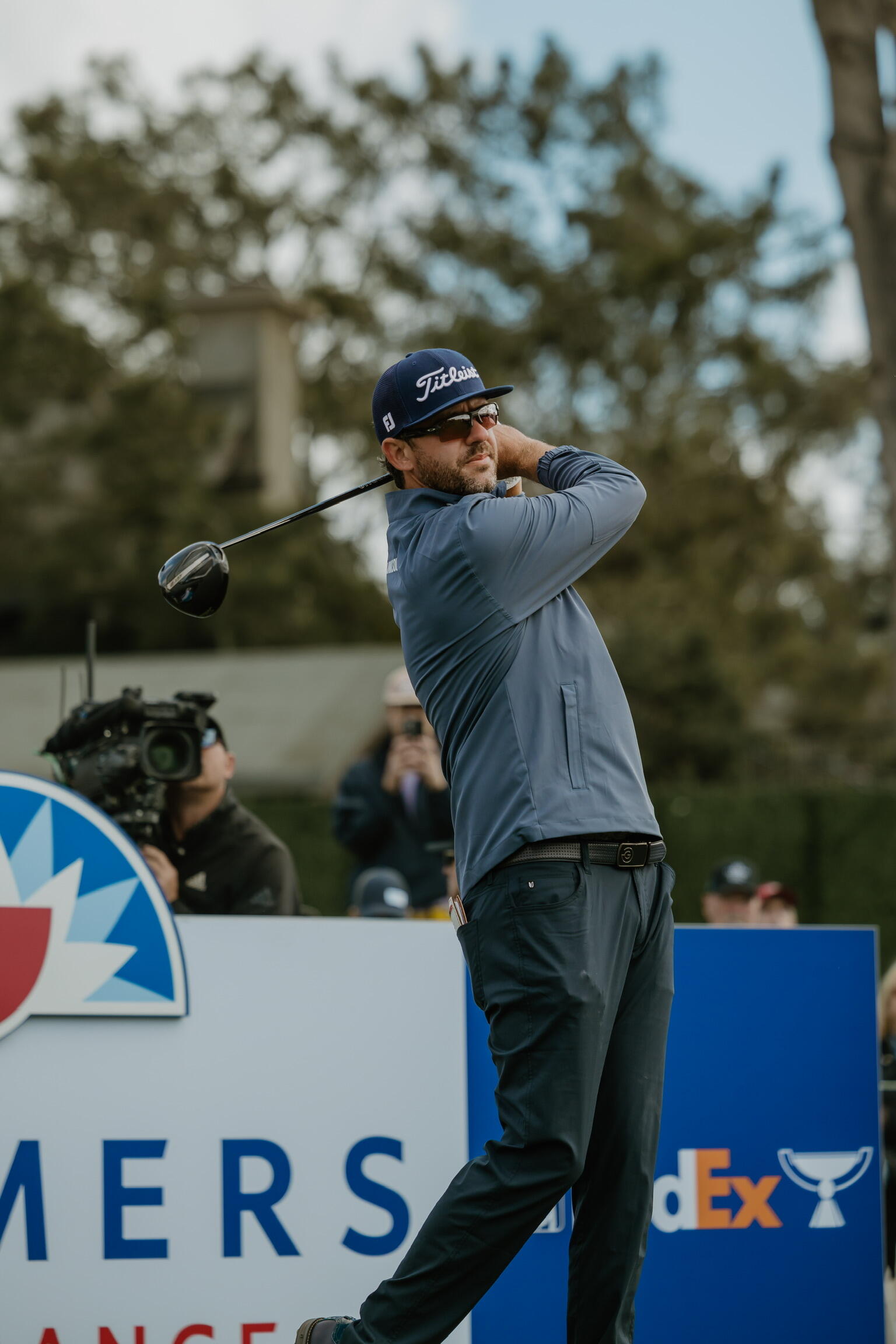 A photo of a man swinging a golf club. 