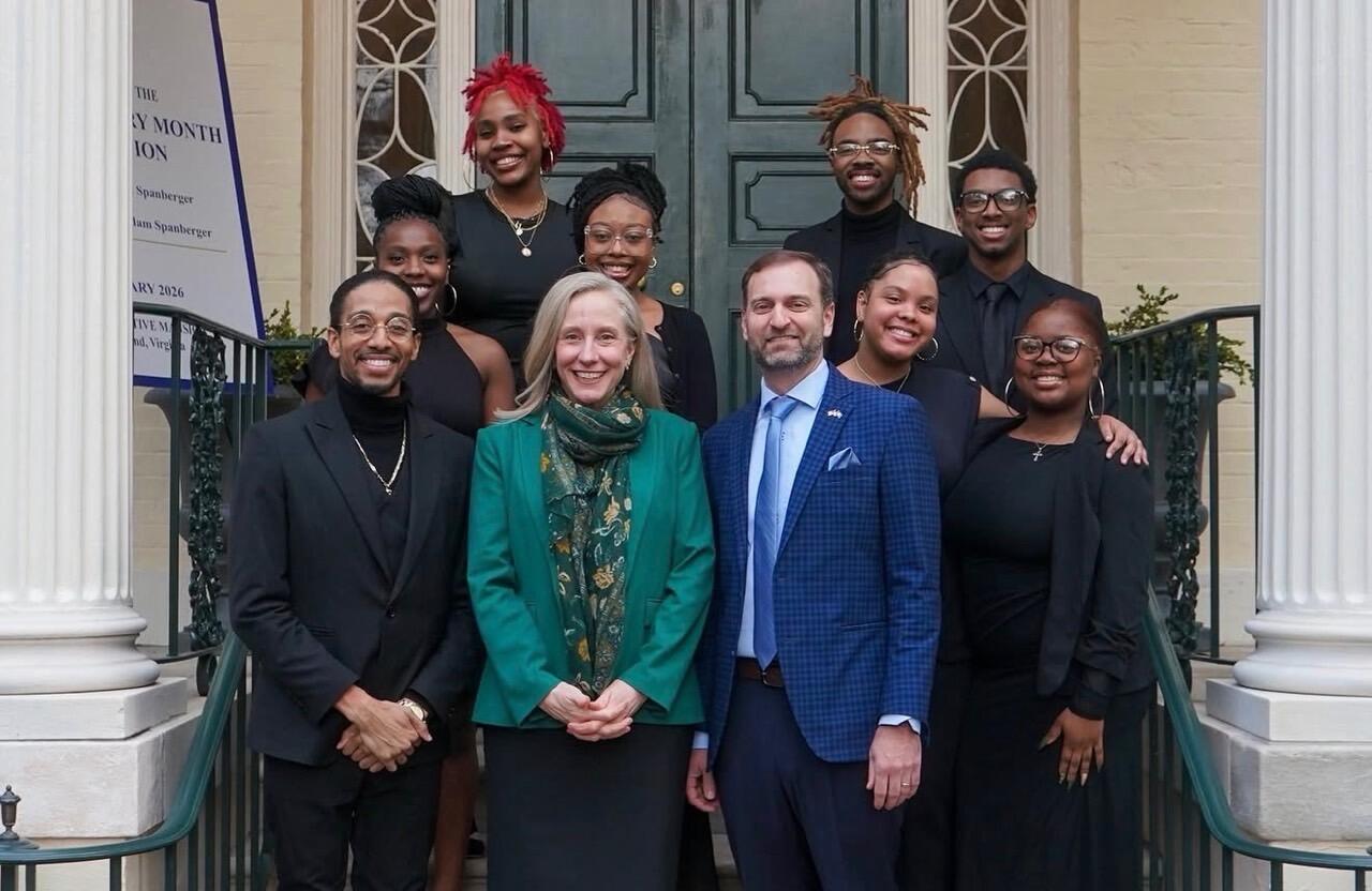 Governor Abigail Spanberger, her husband and members of the Black Awakening Choir pose in front of the Executive Mansion.