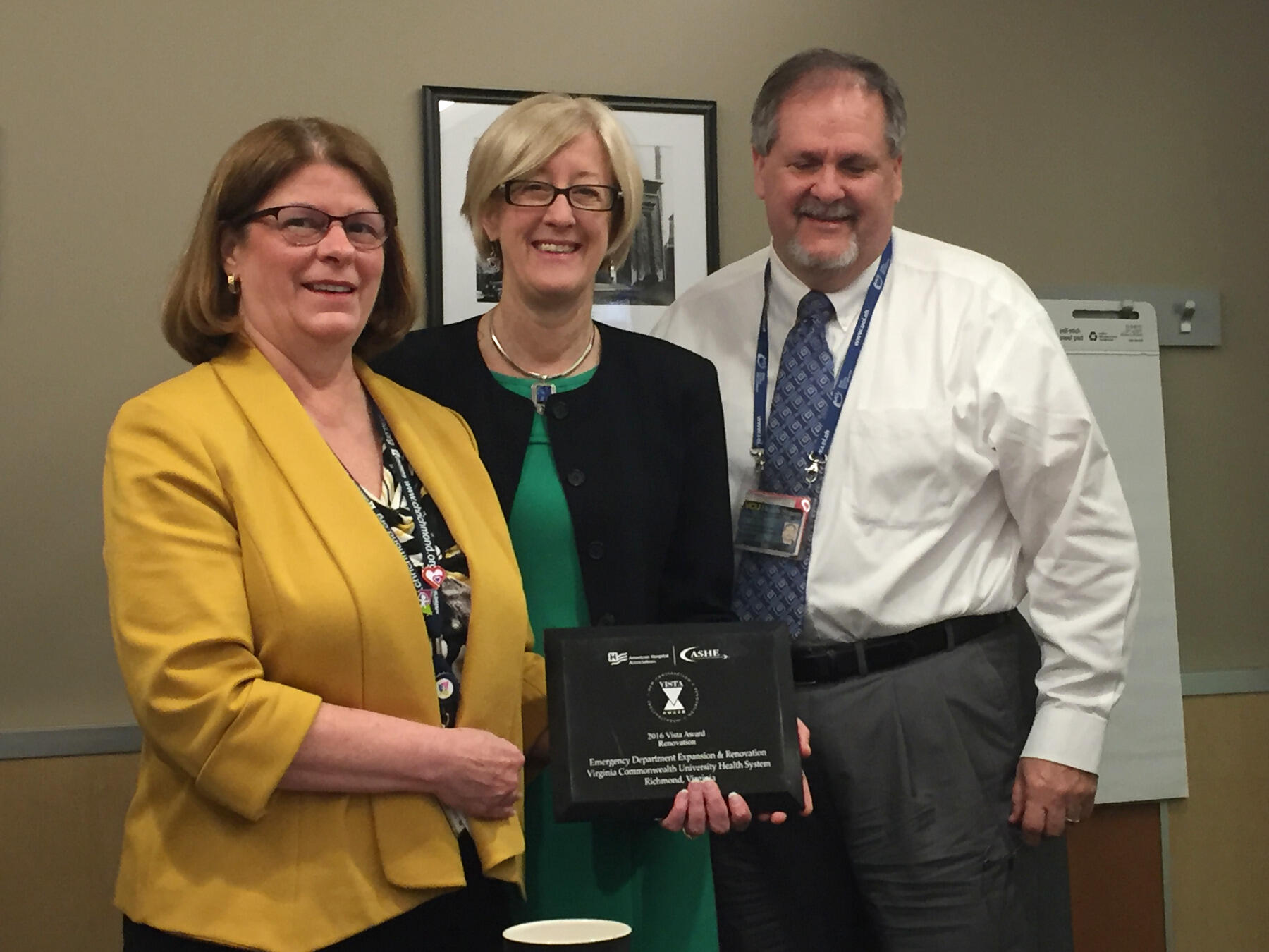 Deborah Davis, chief operating officer of VCU Hospitals; Leslie Hanson, principal and senior vice president in the Richmond office of the architecture firm HKS Inc.; and Larry Little, vice president of support services and planning, VCU Health System, with the Vista Award plaque.
