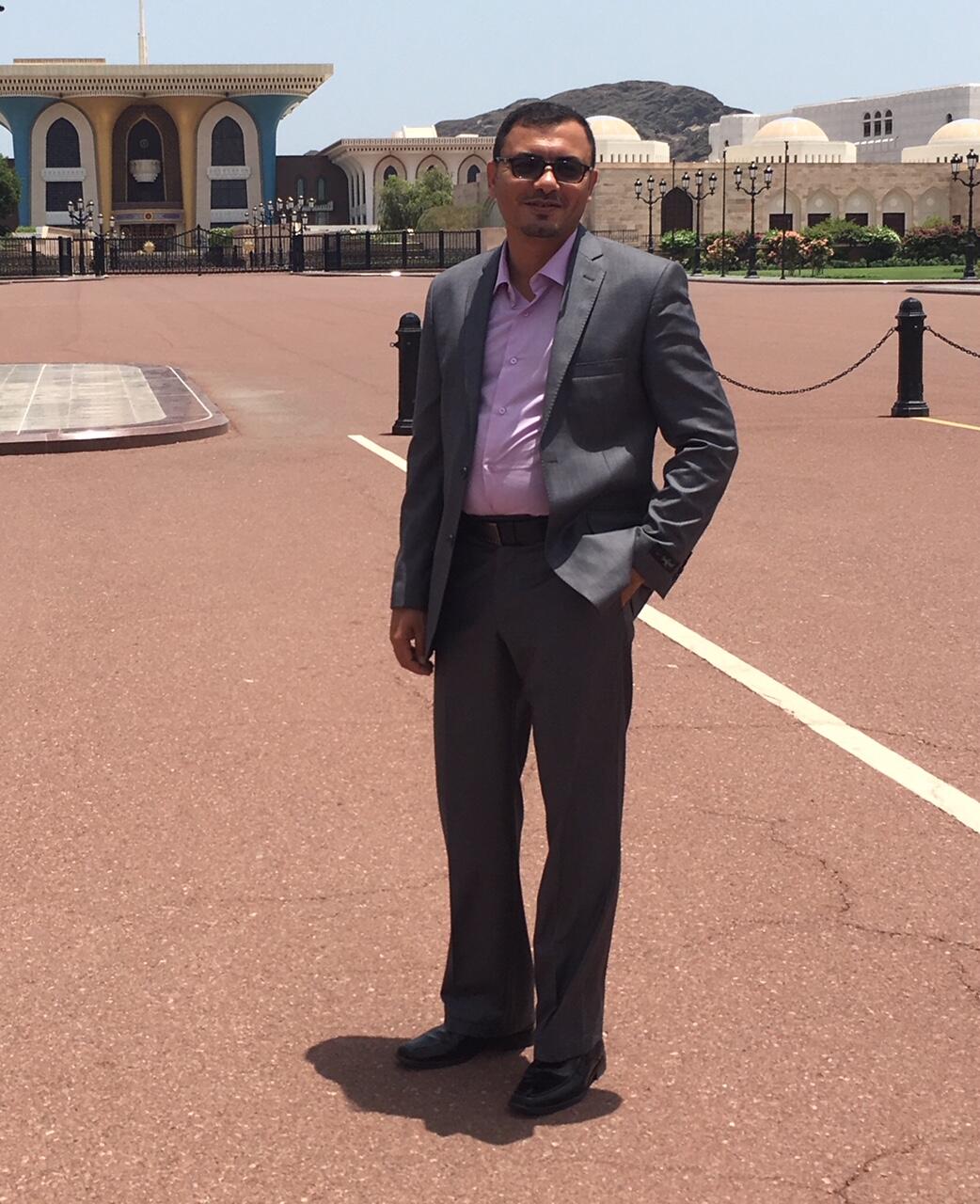 Man in business attire standing outside.